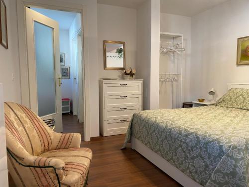 ein Schlafzimmer mit einem Bett, einem Stuhl und einer Kommode in der Unterkunft Appartamento Palazzo Montegnacco-Braida in Udine