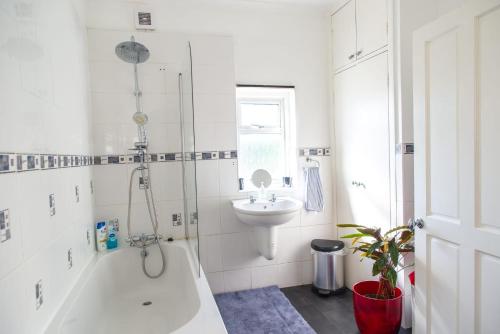 y baño con bañera, lavamanos y ducha. en Rare London 6bedroom House en South Norwood