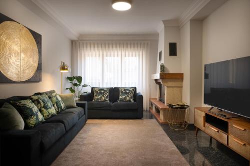 a living room with a couch and a television at Home Essences in Porto