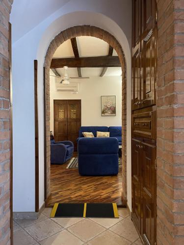 a living room with a blue couch and an archway at Mazzetti Country House-Vita in campagna con giardino in Vimignano