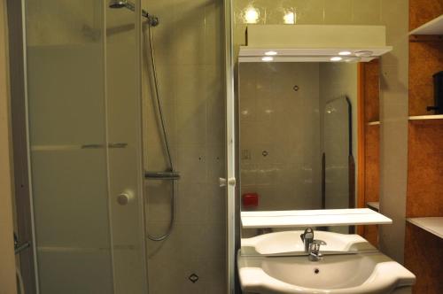 une salle de bain avec un lavabo et une douche avec un miroir dans l'établissement Olympe - 104 - Studio - 4 pers, à Les Deux Alpes