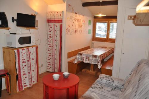 Cette chambre comprend un salon avec une table et une télévision. dans l'établissement Olympe - 104 - Studio - 4 pers, à Les Deux Alpes
