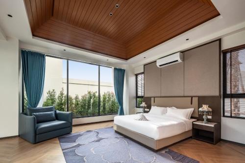 喬木提恩海灘的住宿－圣地亚哥别墅度假酒店，一间卧室配有一张大床和一把椅子