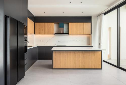 a kitchen with black and wooden cabinets and a counter at Sun Diego Resort Pool Villa in Jomtien Beach