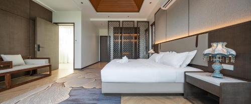 a bedroom with a large white bed and a couch at Sun Diego Resort Pool Villa in Jomtien Beach