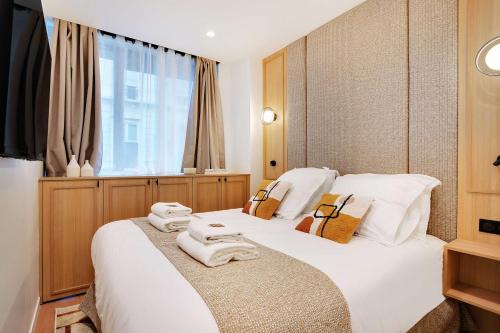 a hotel room with two beds with towels on them at Exceptional AC cocoon Heart of the 9th in Paris