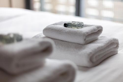 a pile of towels with a ring on top of them at Magnificent 2 BR flat, Caledonian Road in London