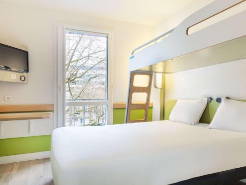 1 dormitorio con cama blanca y ventana en ibis budget Issy Les Moulineaux Paris Ouest, en Issy-les-Moulineaux