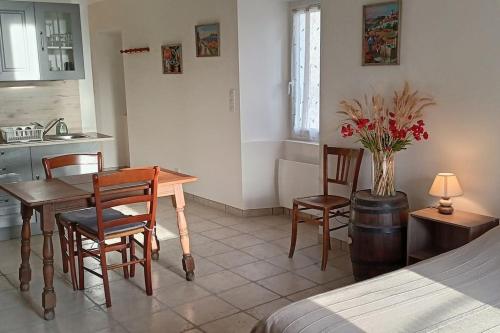 une cuisine avec une table et des chaises dans une pièce dans l'établissement La maison de Marie-Blanche, à Melve