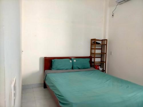 a small bedroom with a bed with green sheets at TN's House in Danang