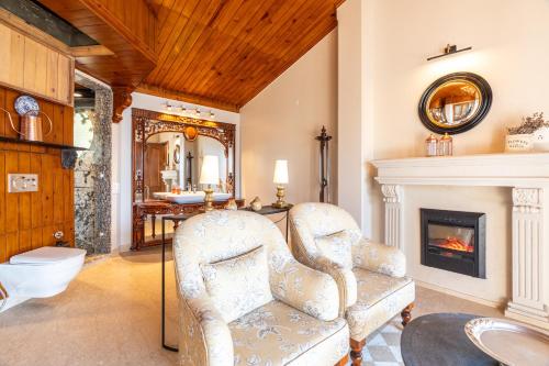 a living room with a chair and a fireplace at SaffronStays Naiintara in Nainital