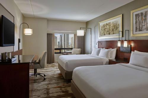 a hotel room with two beds and a desk at Hilton Denver City Center in Denver