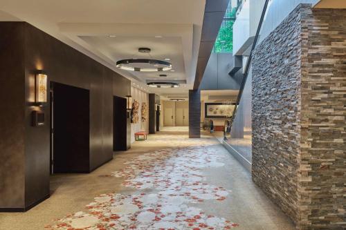 a hallway with a stone wall and a floor with red flowers at Hilton Denver City Center in Denver