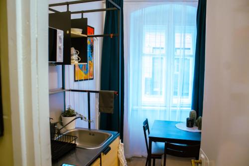 a kitchen with a sink and a table and a window at Lima Mini - cozy apartment - in Győr