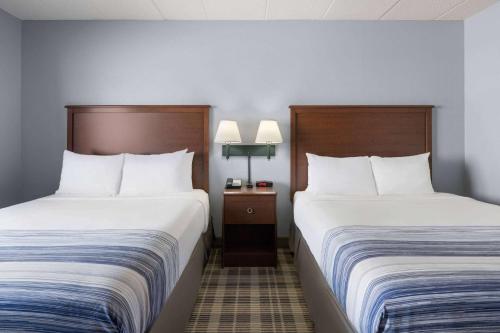 two beds in a hotel room next to each other at AmericInn by Wyndham Stuart in Stuart