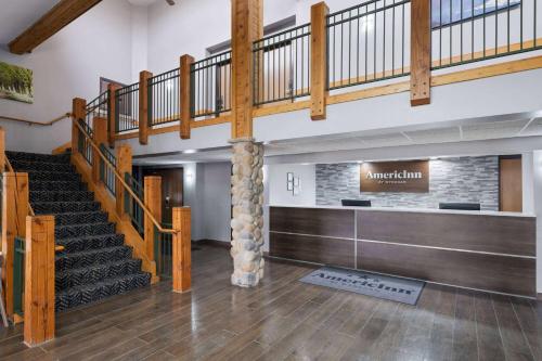 un gran vestíbulo con una escalera en un edificio en AmericInn by Wyndham Stuart, en Stuart