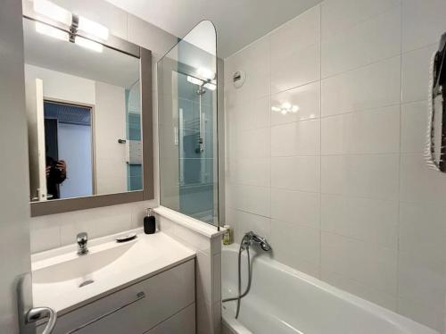 une salle de bain avec un lavabo, une baignoire et un miroir dans l'établissement Très Bel Appartement Palais Festivals Plage Croisette Suquet, à Cannes