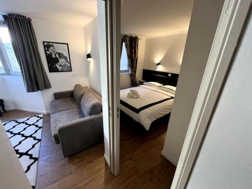 une chambre avec un lit, un canapé et un miroir dans l'établissement Très Bel Appartement Palais Festivals Plage Croisette Suquet, à Cannes