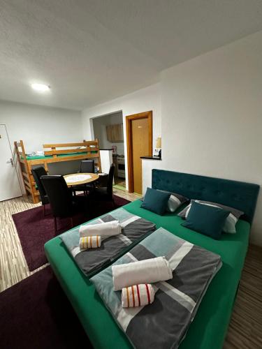 uma grande cama verde num quarto com uma mesa em Guest House Nana em Mostar