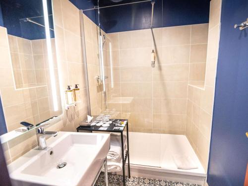 a bathroom with a tub and a sink and a shower at Hôtel Mercure Rochefort La Corderie Royale in Rochefort