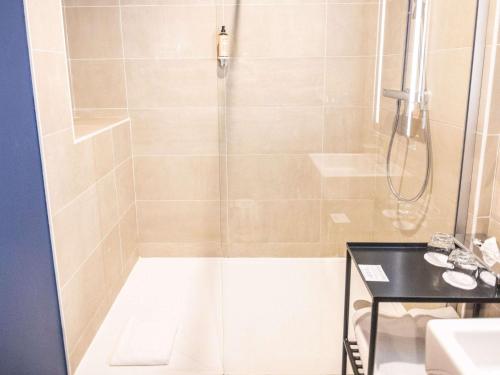 a shower with a glass door in a bathroom at Hôtel Mercure Rochefort La Corderie Royale in Rochefort