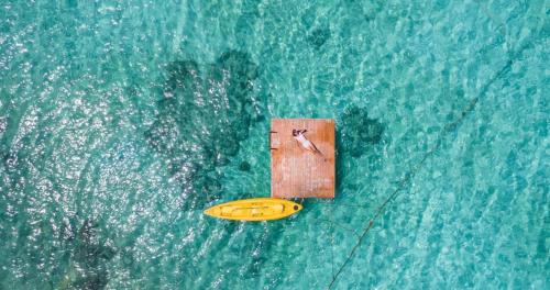 a yellow surfboard in the middle of the water at The Cliff Lipe in Ko Lipe