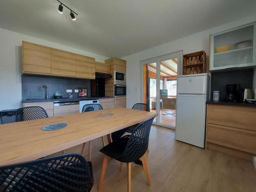 une cuisine avec une grande table et des chaises en bois dans l'établissement Entre lac et montagne, côté calme, spacieux 3 pièces avec grand jardin, à Saint-Jorioz