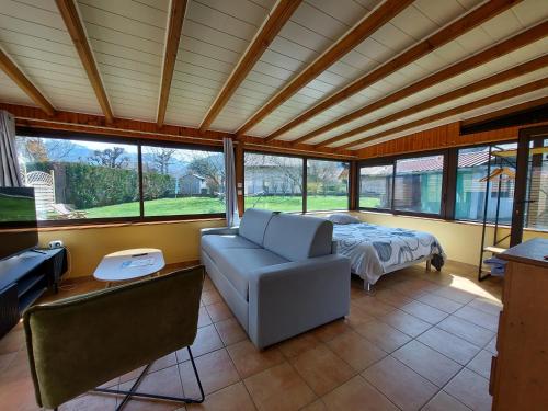 sala de estar con sofá y cama en Entre lac et montagne, côté calme, spacieux 3 pièces avec grand jardin, en Saint-Jorioz