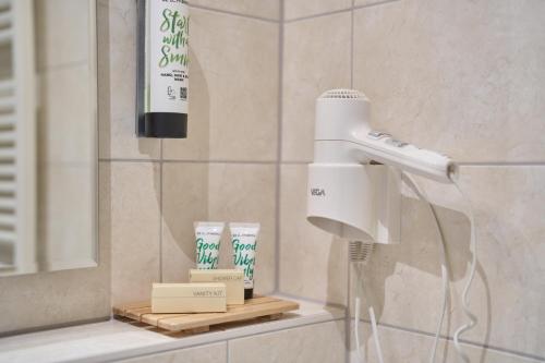 a hair dryer on a shelf in a bathroom at Hotel am Hof in Taufkirchen