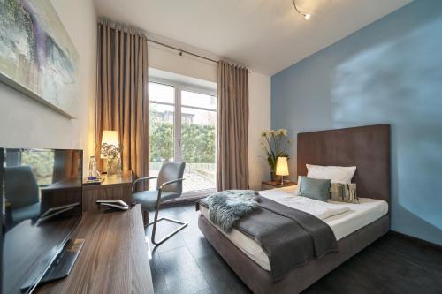 a bedroom with a bed and a desk and a chair at Hotel am Hof in Taufkirchen