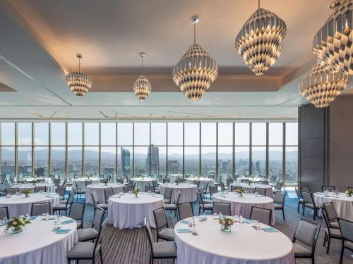 a restaurant with white tables and chairs and chandeliers at Sofitel Mexico City Reforma in Mexico City
