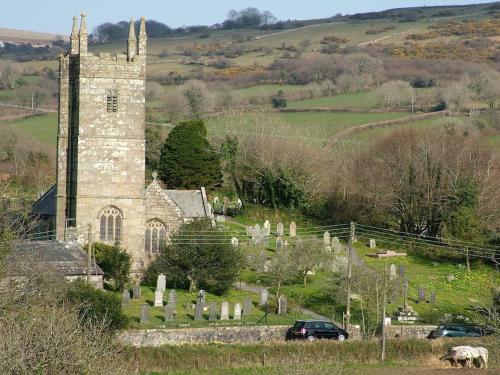 an old church in a cemetery with a car in front at Homer Barn in Tavistock
