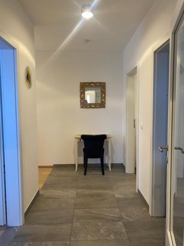 a hallway with a table and a black chair at Burgblick Villach Haus FUX-immo, 10min zum Skifahren, 10 min zum See, rundherum Wandern und Radeln in Villach