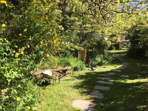 a park with a bench in the grass and trees at Homer Barn in Tavistock