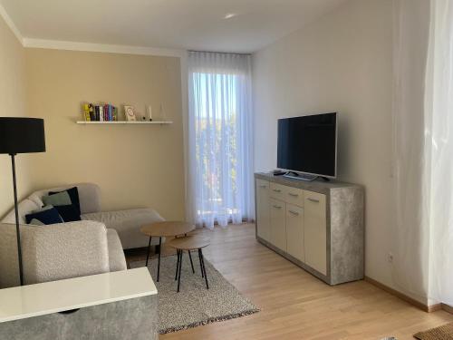 a living room with a flat screen tv on a cabinet at Burgblick Villach Haus FUX-immo, 10min zum Skifahren, 10 min zum See, rundherum Wandern und Radeln in Villach