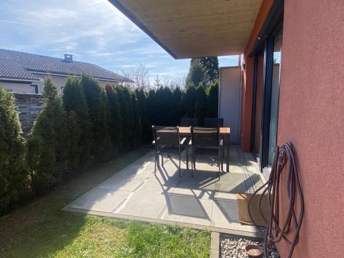 a balcony with a table and chairs on a patio at Burgblick Villach Haus FUX-immo, 10min zum Skifahren, 10 min zum See, rundherum Wandern und Radeln in Villach