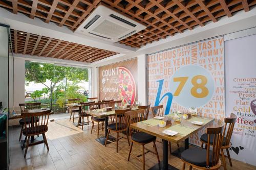 フルマーレにあるh78 veliの木製のテーブルと椅子、壁の看板が備わるレストラン