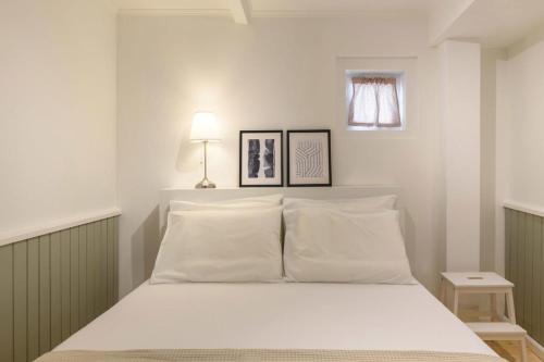 - une chambre avec un lit blanc et 2 oreillers dans l'établissement Keramidogatos Manos Guest House, Corfu Old Town, à Corfou