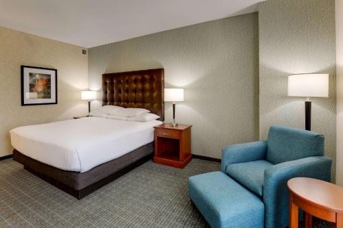 Habitación de hotel con cama y silla en Drury Inn & Suites Phoenix Chandler Fashion Center, en Chandler