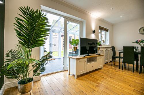 a living room with a desk and a plant at Milton Keynes for Families and Contractors with Private Parking in Milton Keynes