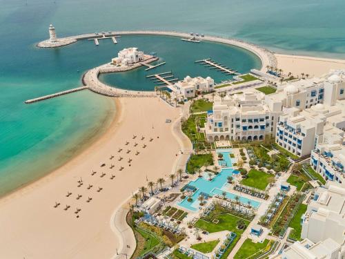 an aerial view of a beach and the ocean at Hilton Salwa Beach Resort and Villas in Abū Samrah