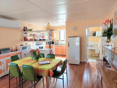 uma cozinha com uma mesa com cadeiras e um frigorífico em Gidget's Place em Surf Beach