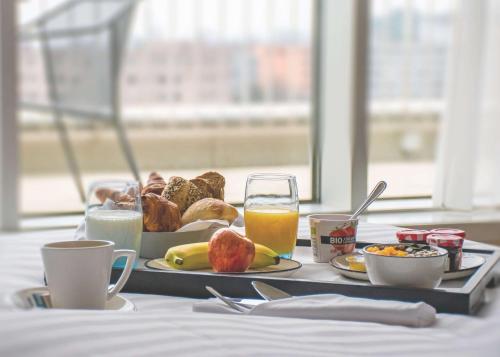 a tray of breakfast foods and drinks on a table at Hilton Geneva Hotel and Conference Centre in Geneva