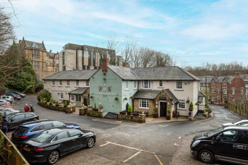 een huis met auto's geparkeerd op een parkeerplaats bij The Kingslodge Inn - The Inn Collection Group in Durham