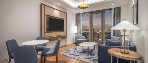a living room with a table and chairs and a tv at Hilton Mall Of Istanbul in Istanbul