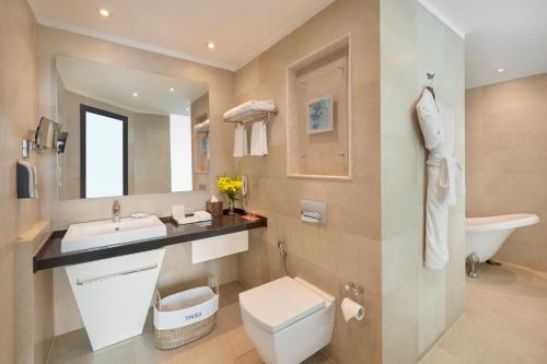 a bathroom with a toilet and a sink and a mirror at Welcomhotel by ITC Hotels, Dwarka, New Delhi in New Delhi