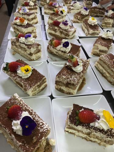 una fila de postres en platos blancos en una mesa en Hotel Elyon Dej en Dej