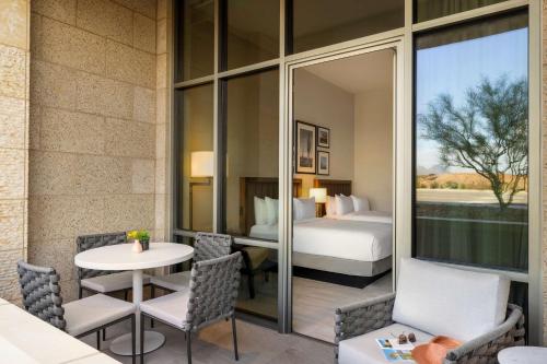 a room with a bed and a table and chairs at Hilton North Scottsdale At Cavasson in Scottsdale