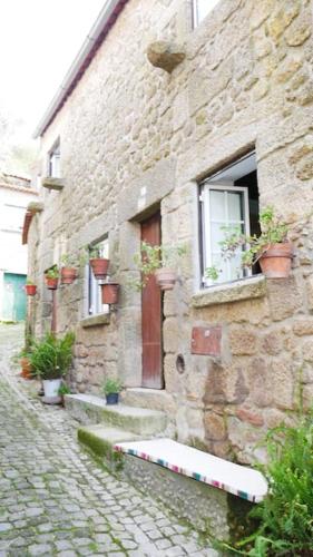a stone building with a window with potted plants on it at Artsy Short Term Rentals Monsanto in Monsanto