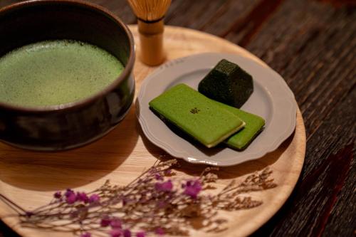 京都市にあるSaju Kyoto 茶住 京都の緑のプリンの皿の横に並ぶ緑の液体